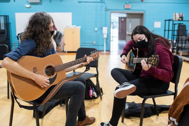 Music Therapy instructor Timothy Honig works with a student in the class Functional Guitar