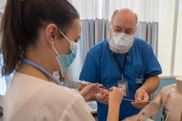 A Westfield State Nursing student assists with a procedure