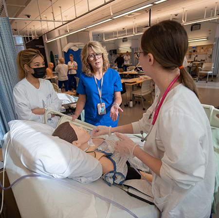 Nursing students with instructor Jean Prast in the sim lab