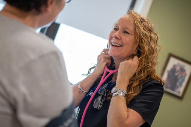 Health Services Director Kelly Palm with stethoscope and patient