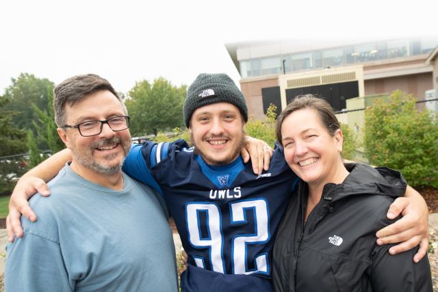 A WSU student flanked by his parents, smile at the camera