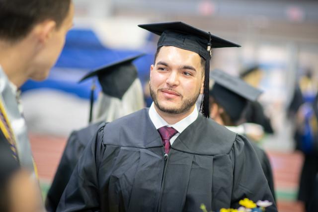 Student at Graduate Commencement wearing cap and gown
