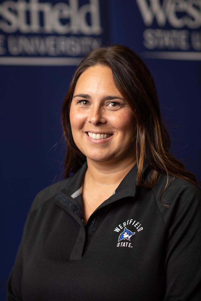 Katelyn Associate Director of Admission wearing navy WSU logo polo shirt smiling with long brown hair.