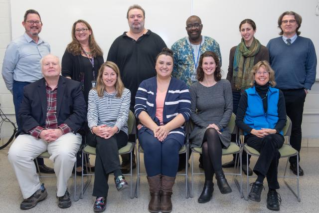 Eleven History Department faculty members smiling in group photo. Six are standing and five are sitting.