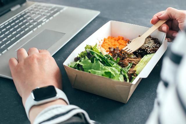 Employee eating lunch at computer.