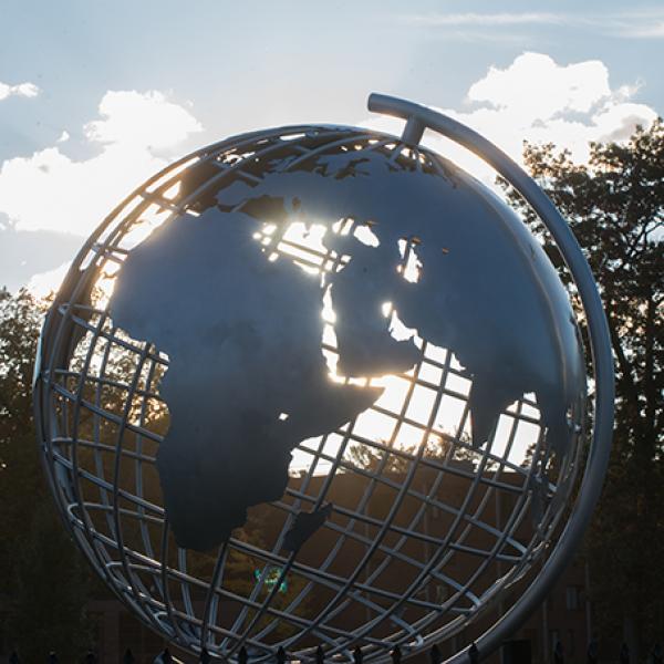 Sunlight streams through the globe sculpture on the campus green