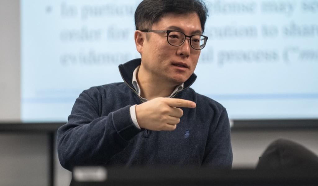 Professor talking to class in front of powerpoint screen
