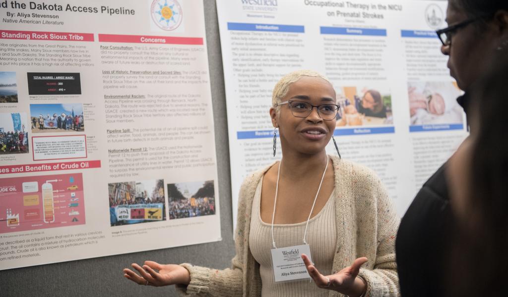 Female WSU student explains her research during CURCA presentations