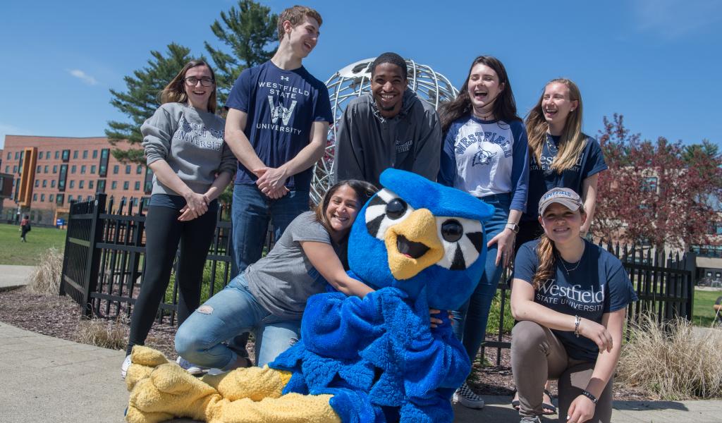 nestor surrounded by students in front of the globe on the campus green