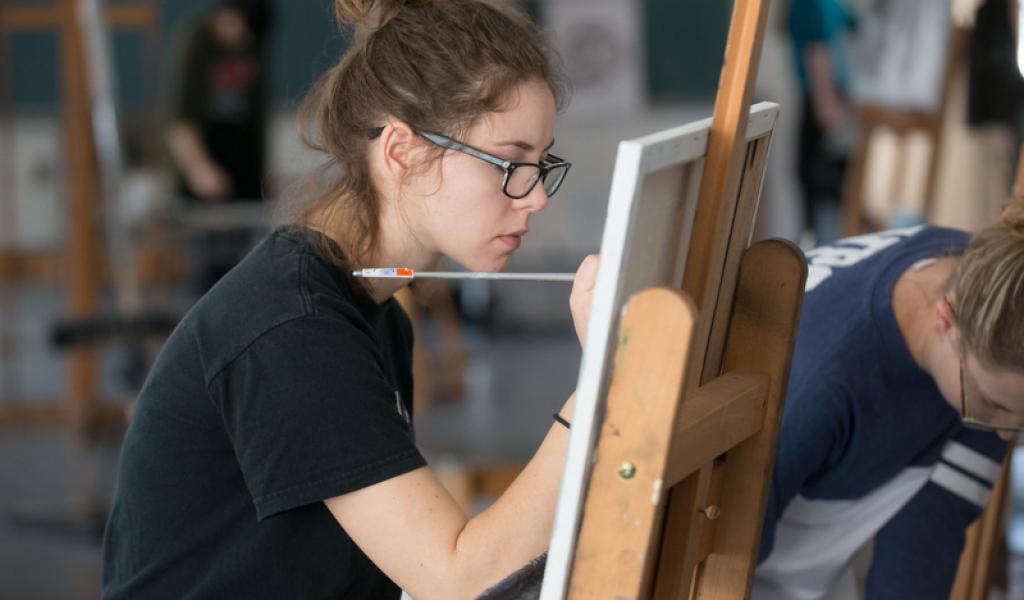 Student painting still-life scenes in the Dower Center for the Arts