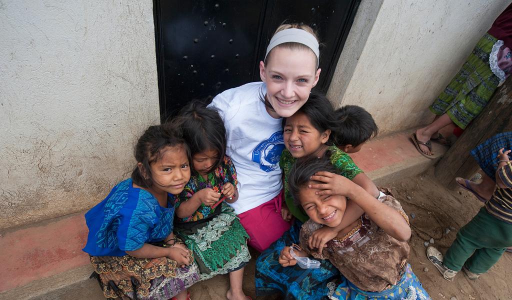 Nursing student surrounded by children in Guatemala