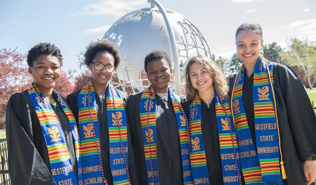 Sankofa scholars smiling at the campus globe.