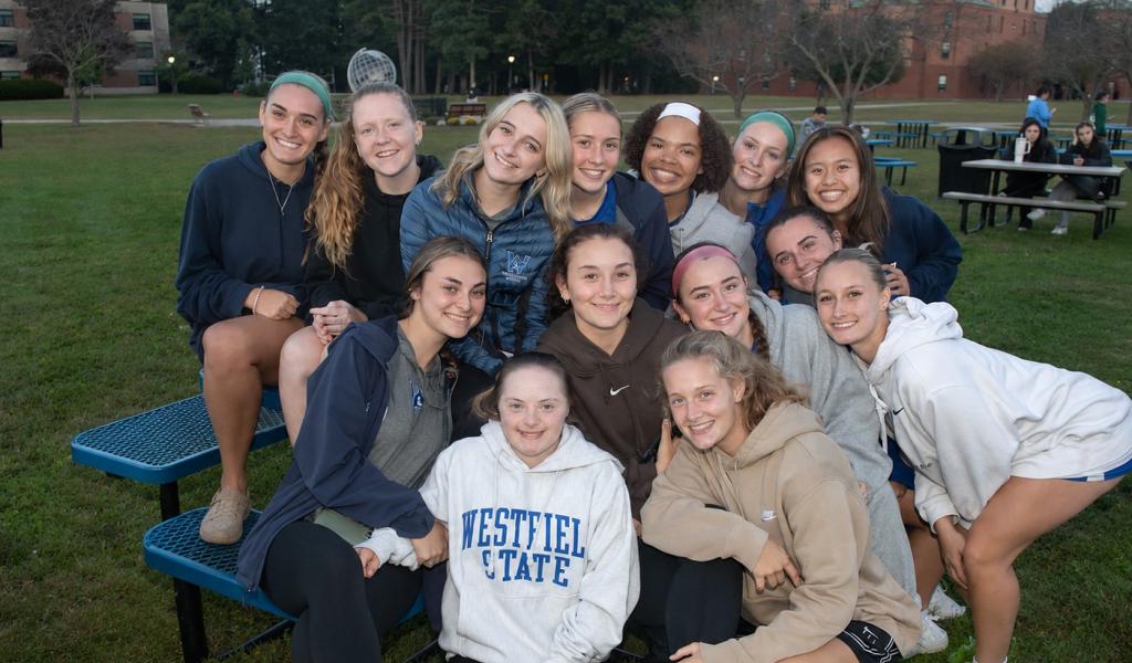 Students smiling together at a pep rally on the green.