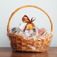 Gift basket on table, wrapped with bow.