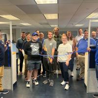 Matt Dellea, Jack Guindon, and Joshua Hattrick cutting a blue ribbon in front of the new commuter lounge.