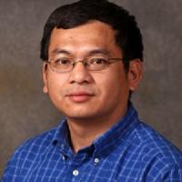 Dr. Liem Nguyen wearing blue plaid shirt and glasses.