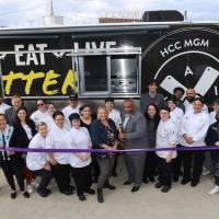 A food truck at Holyoke as part of their initiative to promote healthy eating. Stacy Graves '05, Facility Coordinator for the Culinary Arts Institute at Holyoke Community College, stands around a crowd of her students who will be in charge of the truck. 